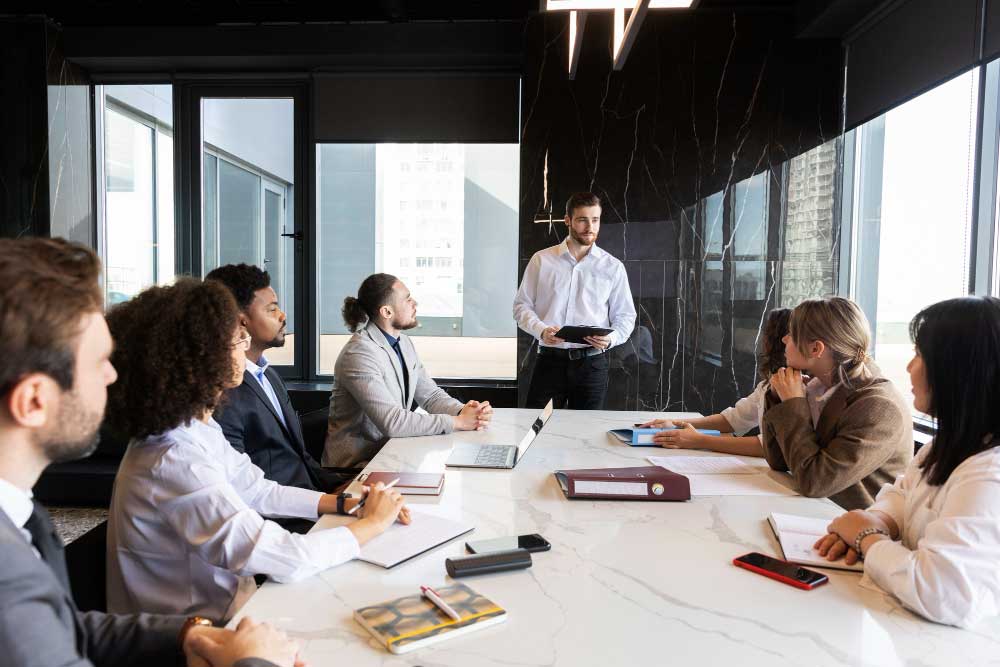 Business executive presenting strategy to a team in a modern conference room, representing collaborative financial planning and expert transaction support through M&A Advisory California services.