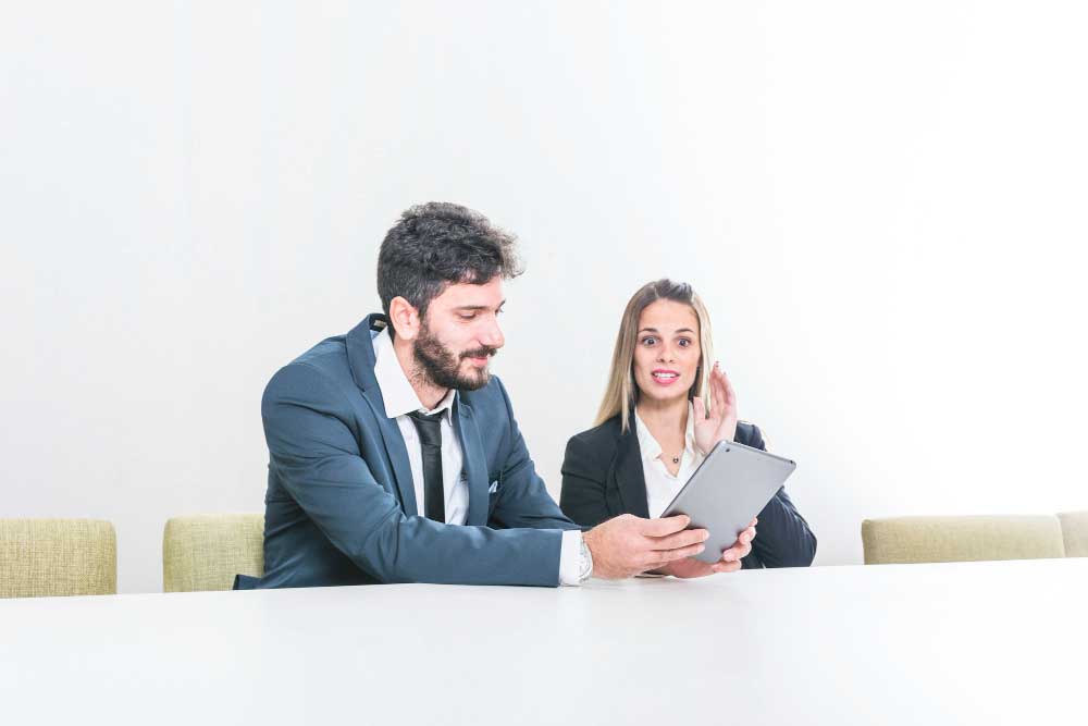 Professional business consultant shaking hands with a client while holding documents in an office, representing successful negotiations and expert transaction guidance through M&A Advisory Washington services.